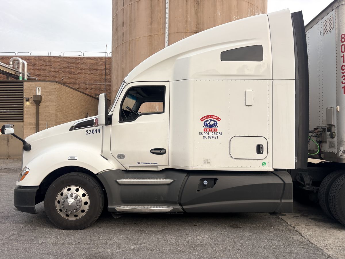 Side of the cab showing the Omega World Trade logo with US DOT 1734788 and MC 889473